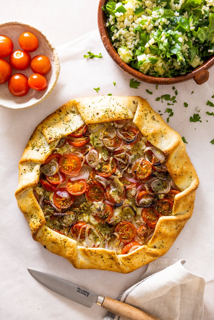 Galette med cherrytomater, chevre, løk og urter, servert med frisk salat