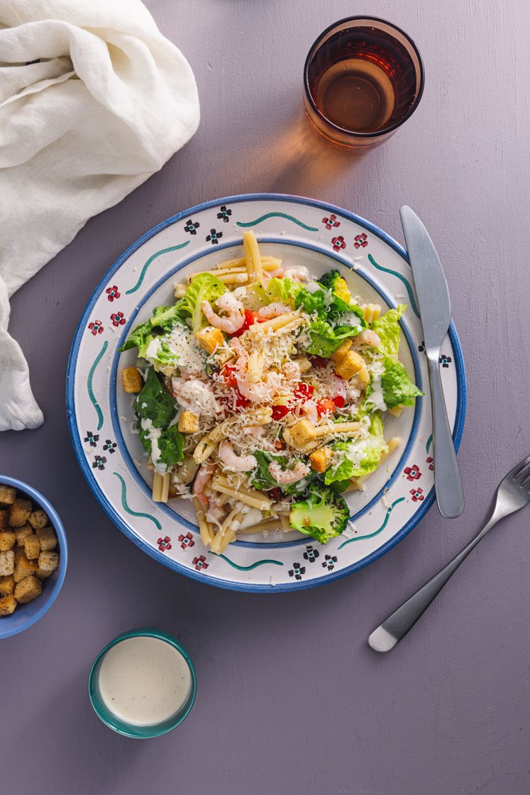Pastasalat med rejer, broccoli og cæsardressing, toppet med croutoner 