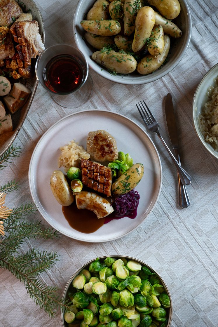 Juleribbe med mandelpoteter, rødkål, rosenkål og medisterkaker, servert med brun saus og rørte tyttebær