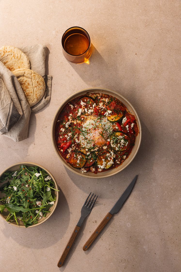 Shakshouka - egg i tunisisk tomatsaus, servert med varme brød, persille og fetaost