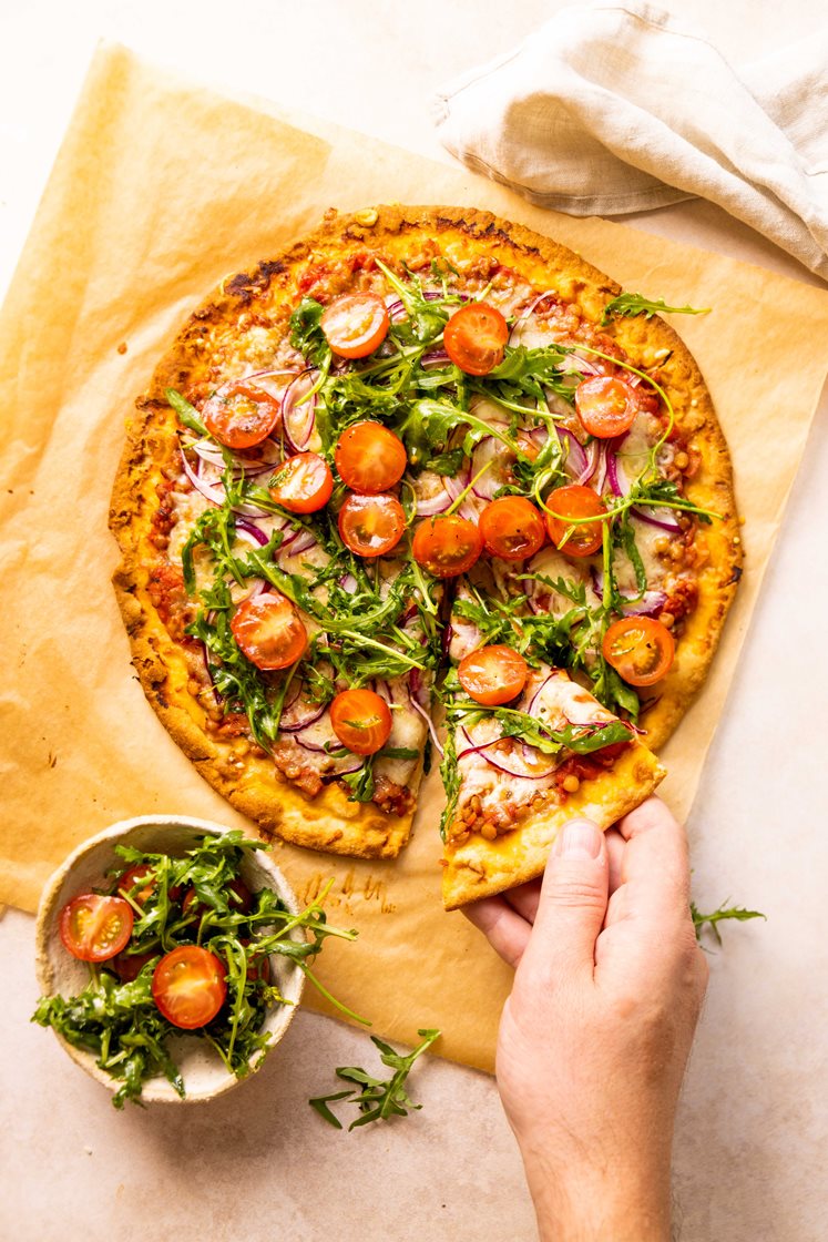 Pizza bolognese serveret med rucola/tomatsalat