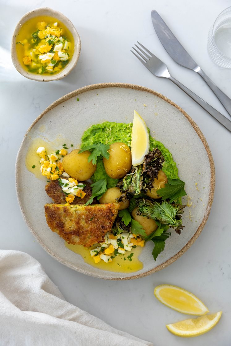 Vegetarschnitzel med kokte poteter og ertepuré servert med grønnkålchips og eggesmør