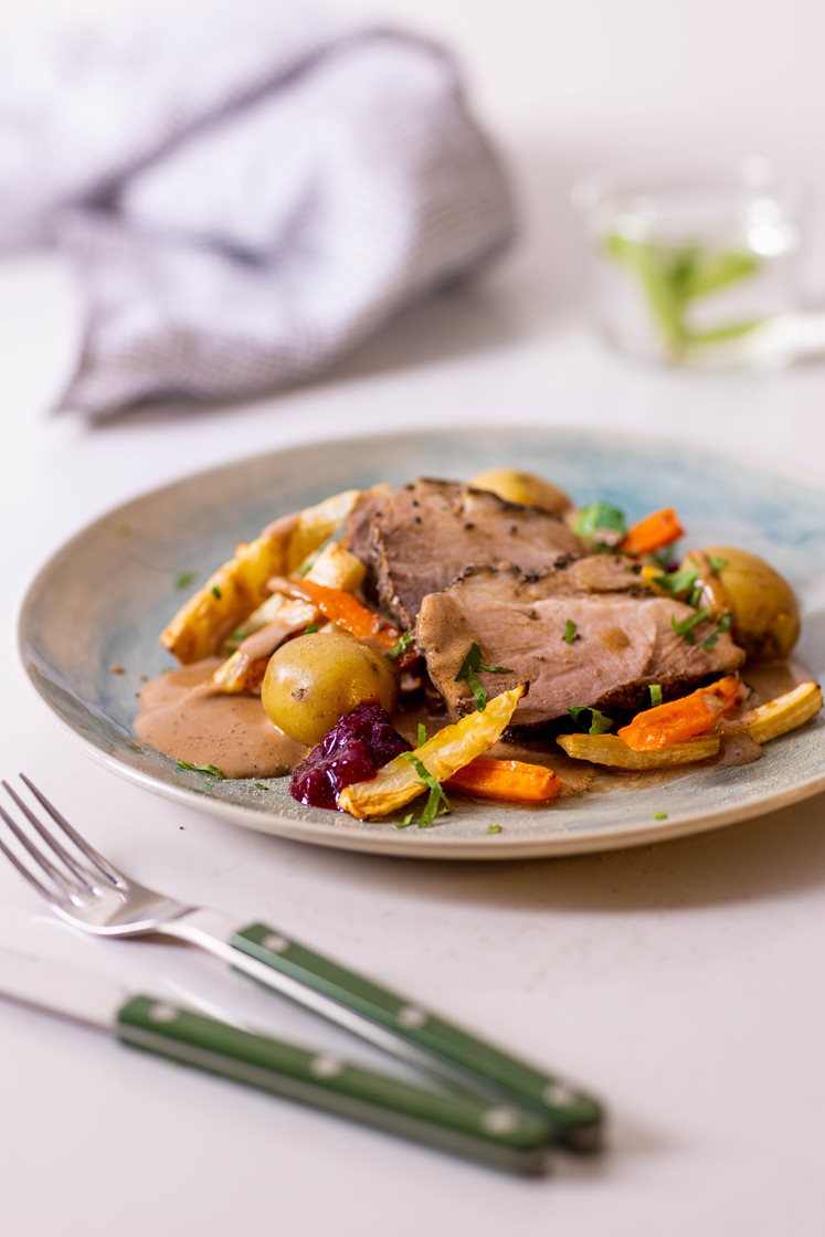 Mørkokt svinenakke i peppersaus med ovnsbakte grønnsaker med persille, servert med rørte tyttebær