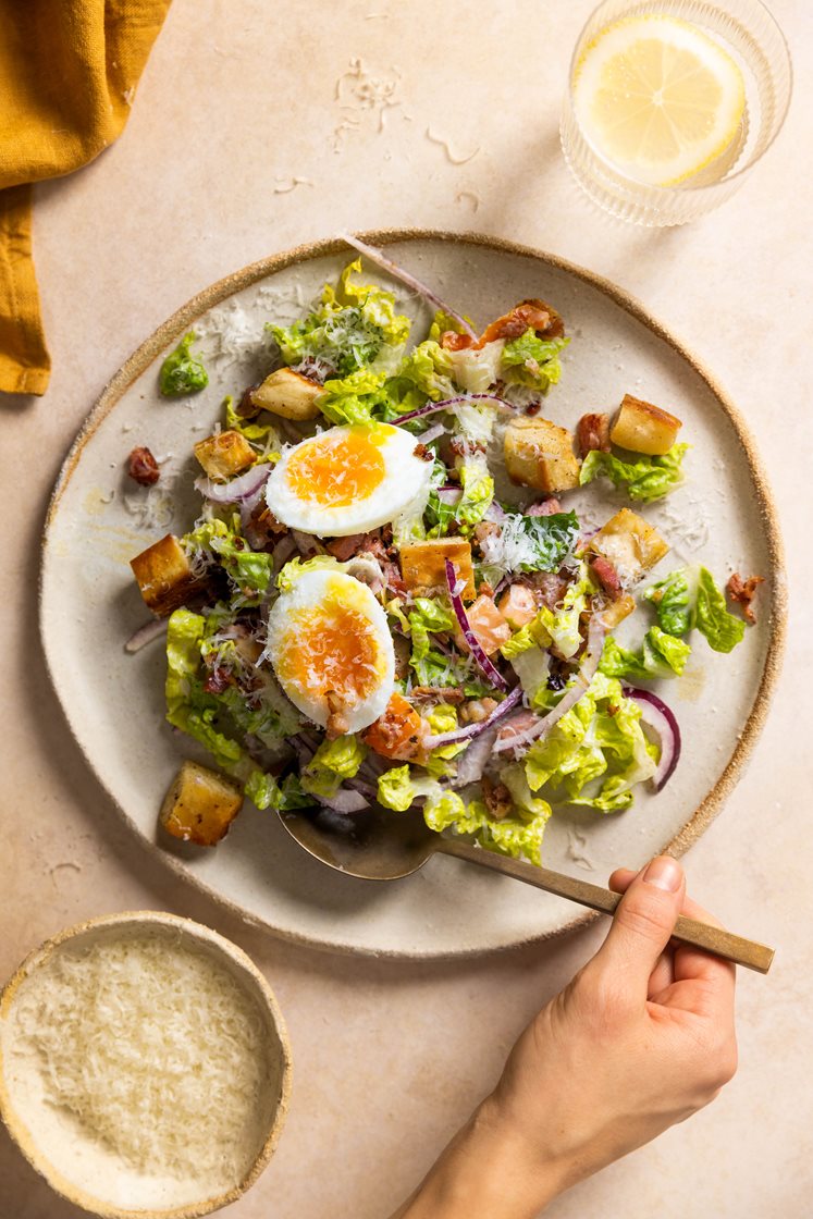 Blandet salat med sprøstekt bacon, bløtkokte egg, brødkrutonger og Grana Padano