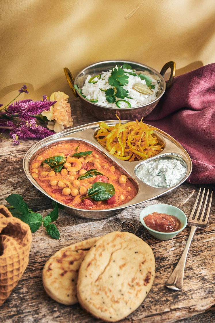 Indisk thali med chana masala, raita och naanbröd