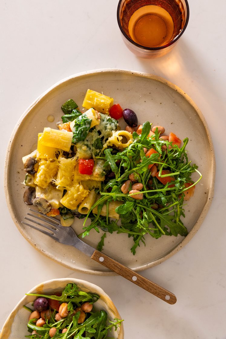 Gratinert pasta mezze maniche i fløtesaus med squash og spinat, servert med ruccola- og tomatsalat