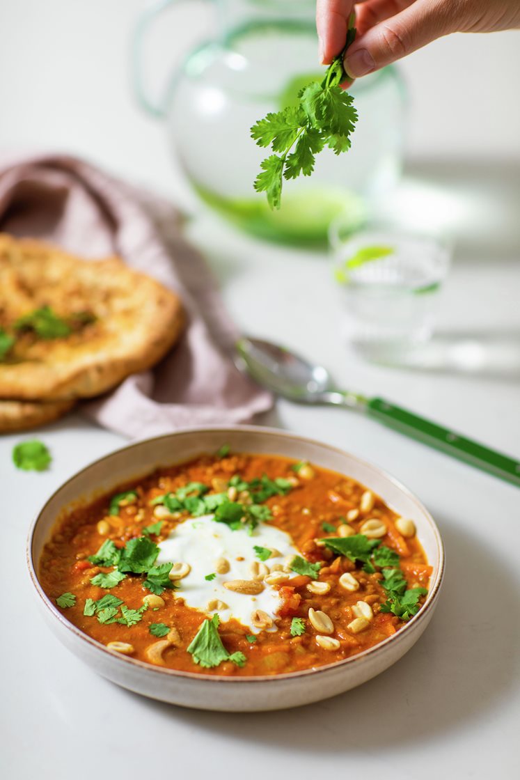 Indisk linsesuppe med koriander og yoghurt, servert med nanbrød og nøtter