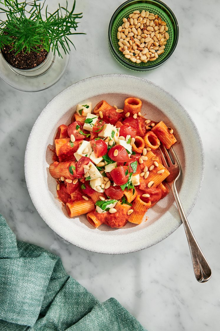 Pasta i tomatsås med mozzarellatopping och pinjenötter