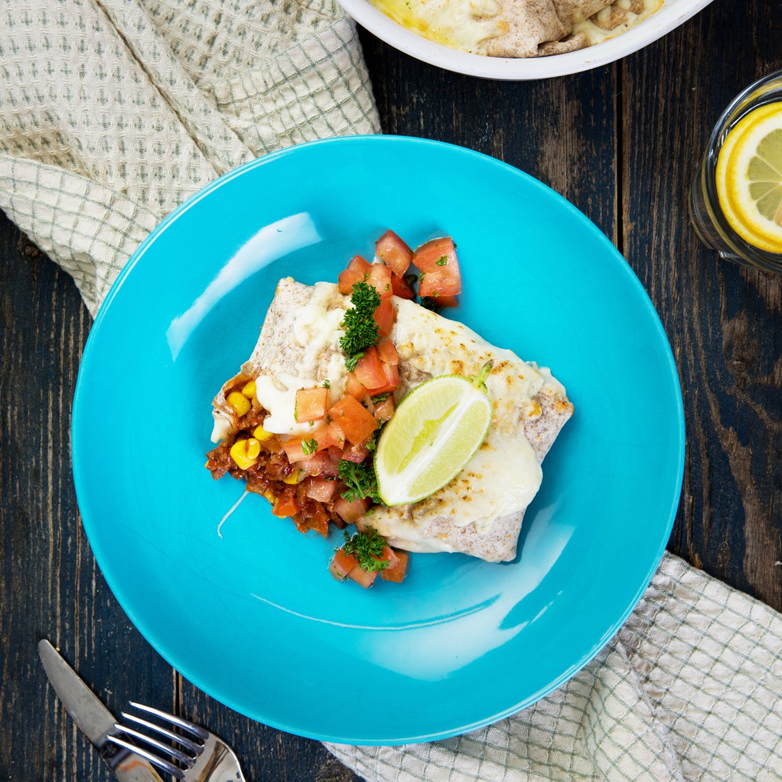 Gratinerte burritos med kjøttdeig servert med frisk tomatsalat og lime