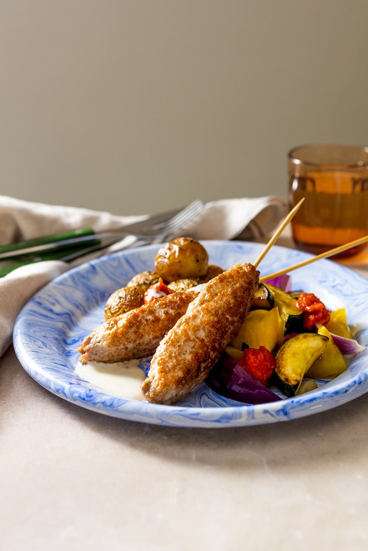 Salsicciaspyd med ovnsbakte urtepoteter, paprika og squash, servert med ajvar og urtedressing