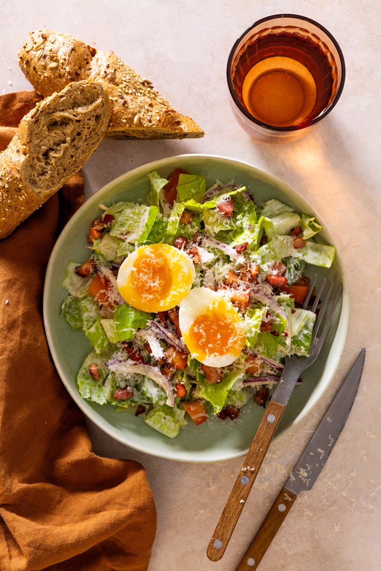 Blandet salat med sprøstekt bacon, smilende egg, lune multibrød og Grande Premium