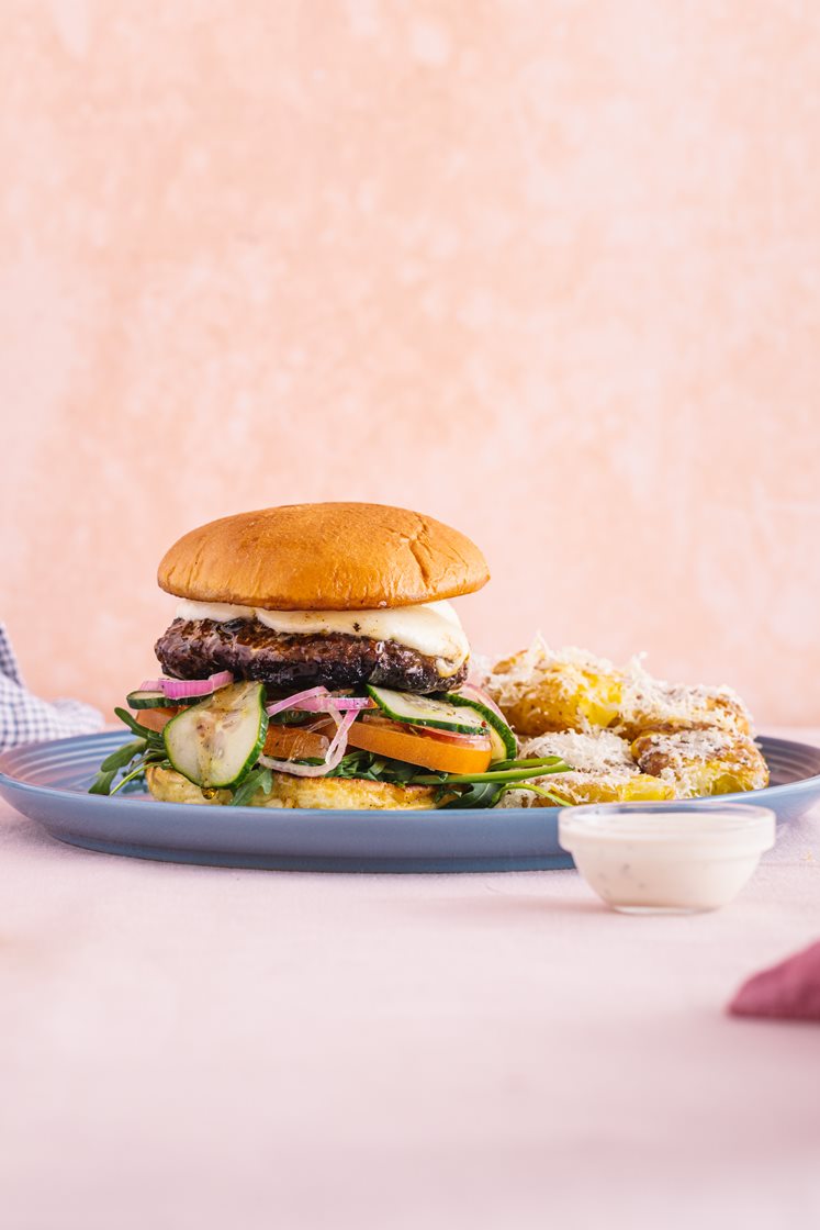 Trøffelburger med mozzarella, smashede krydderkartofler, ﻿syltet agurk, rucola og tomat