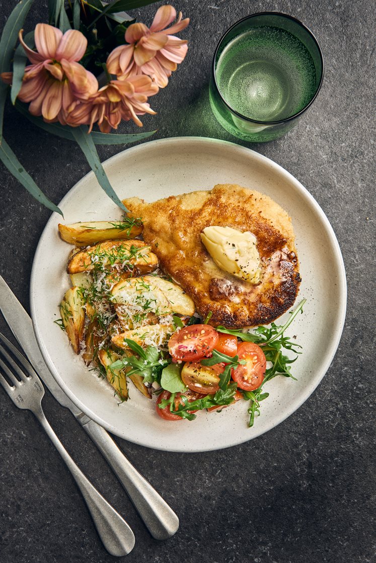 Kycklingschnitzel med dill- och parmesanpotatis, kryddsmör och tomatsallad