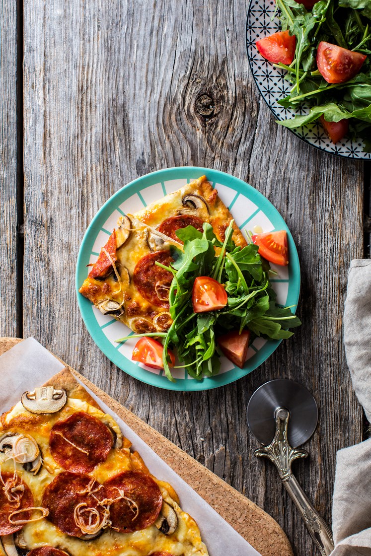 Pepperonipizza med hvit pizzasaus og aromasopp servert med ruccolasalat