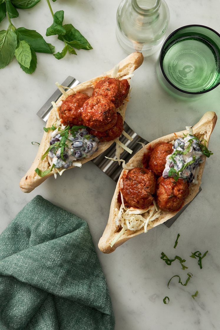 Små kryddiga köttbullar i pitabröd med mynta, spetskål och krämig bönsalsa
