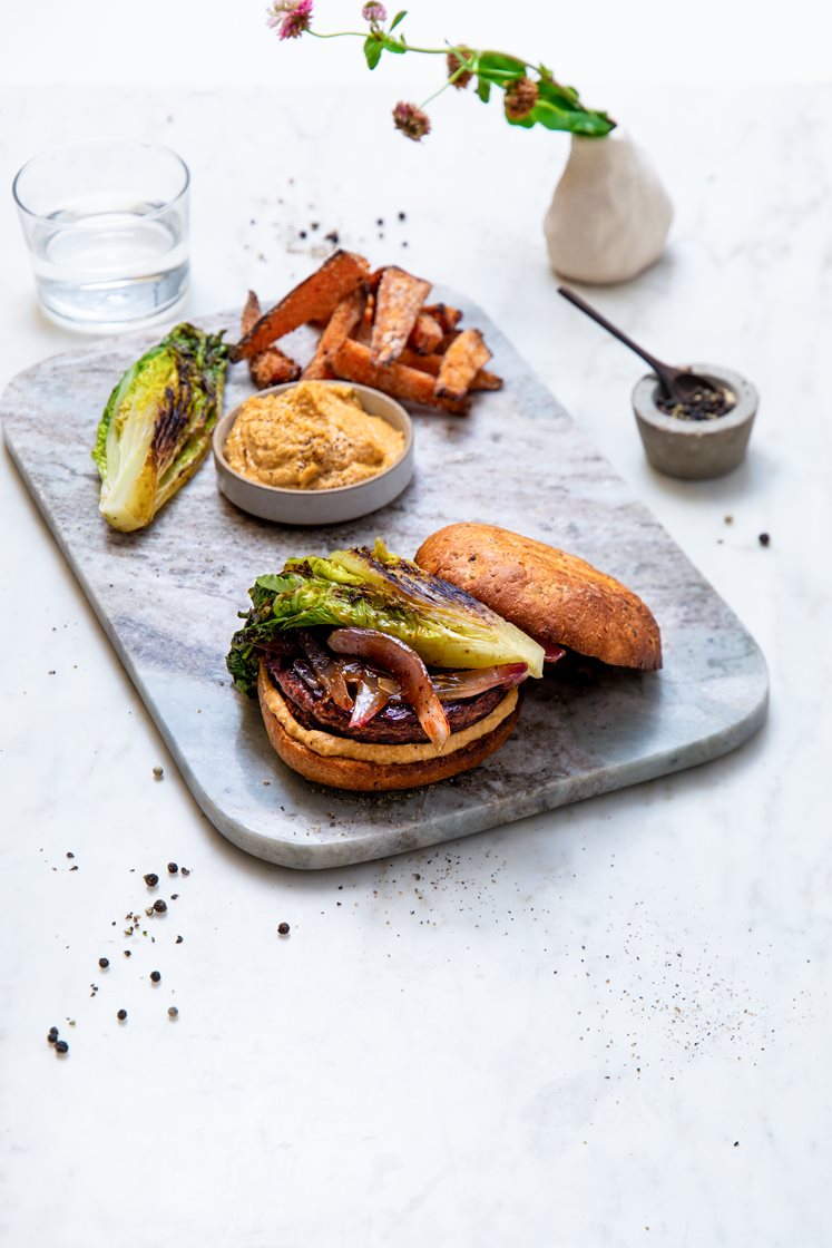 Burger med søtpotetfries, black pepper-glasert rødløk, hummus og grillet hjertesalat