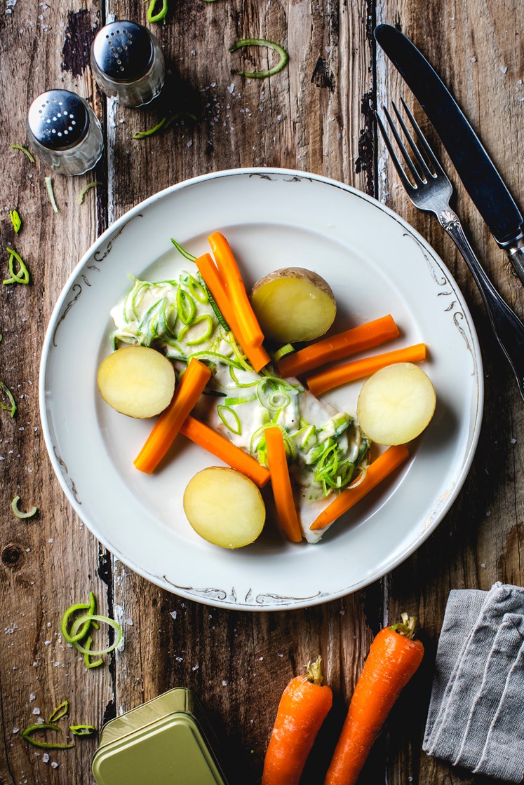 Torsk i kremet purreløksaus med kokte poteter, gulrøtter og sukkererter