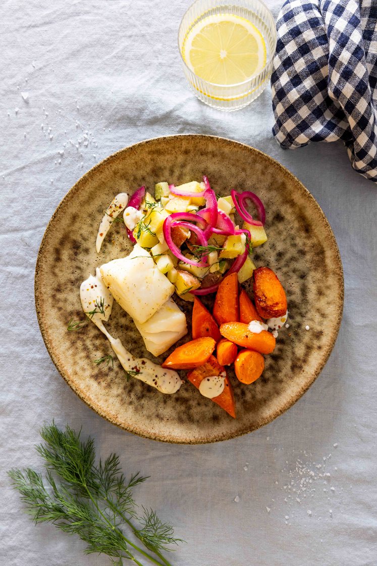 Urtebakt torsk og potetsalat med eple, servert med appelsinbakte gulrøtter og kremet saus 