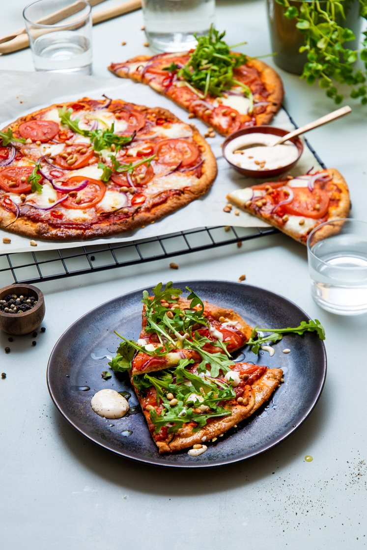 Pizza med fersk mozzarella, ruccola, pinjekjerner og rømmedressing