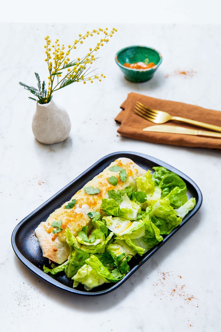 Gratinerte enchiladas fylt med bønner, paprika og skjørost, servert med grønn salat og koriander
