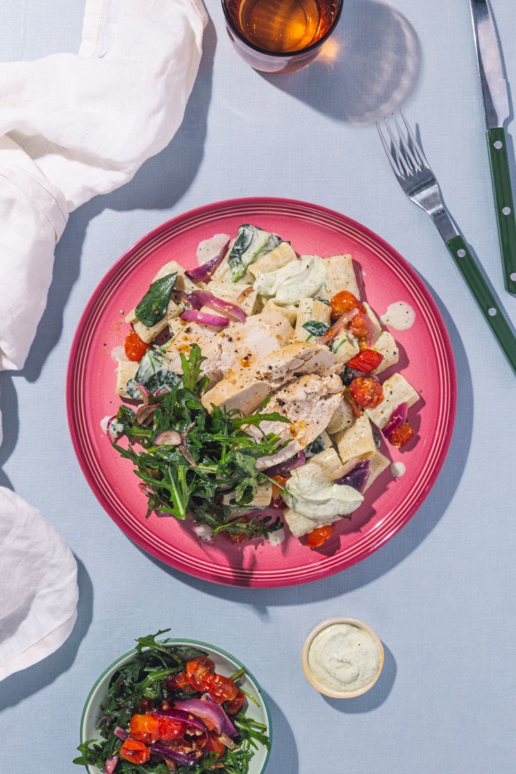 Ovnsbakt kyllingbryst og cherrytomater servert med pasta, pestokrem og ruccolasalat