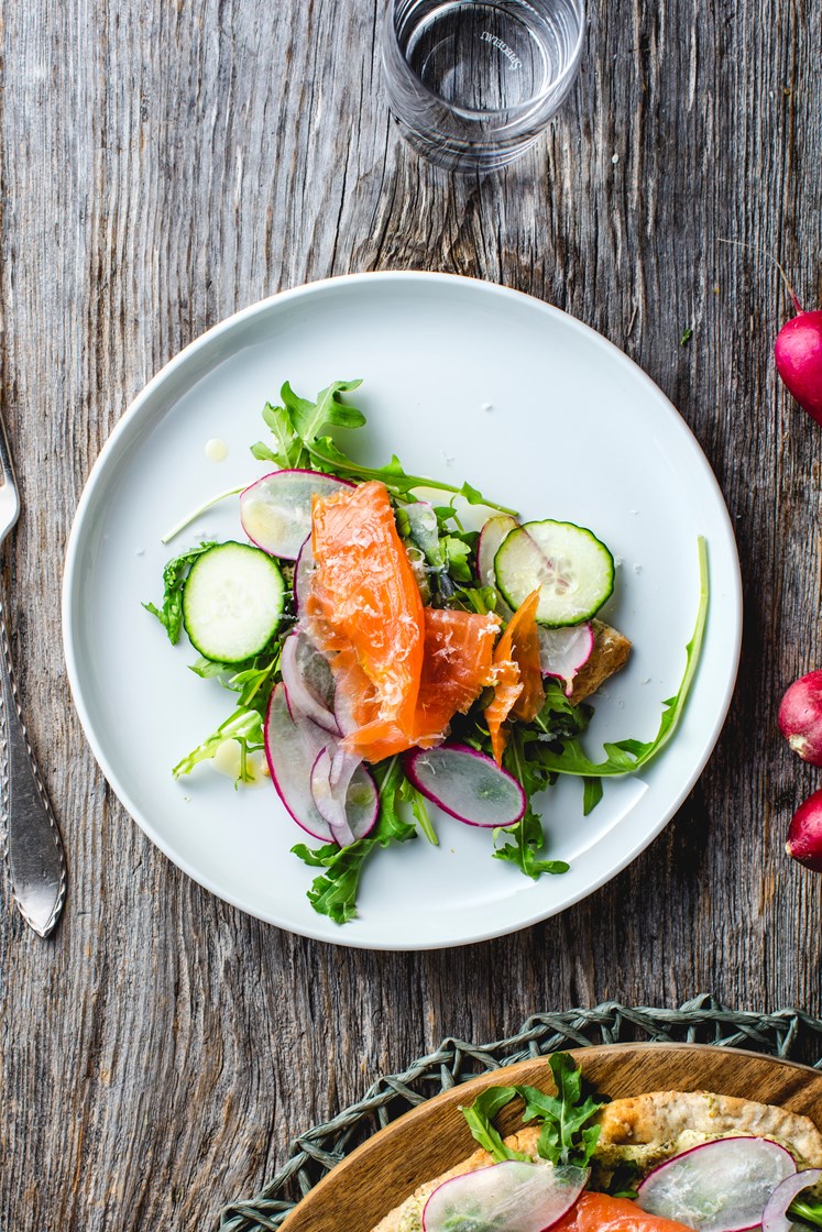 Hvite minipizzaer med varmrøkt krydderlaks, friske grønnsaker og ruccola