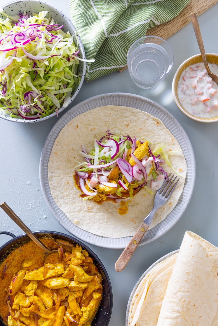 Tortillawraps med skivet kyllingfilet i kormasaus, kålsalat og urtedressing