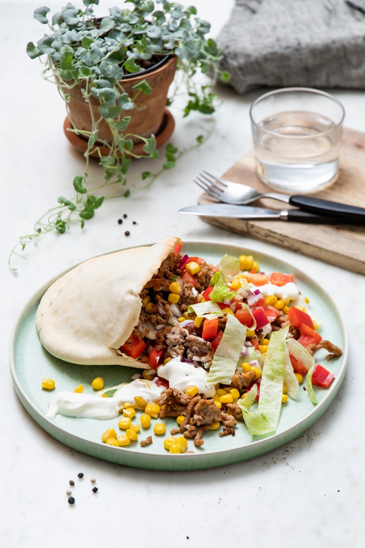 Taco av svinekjøtt i pita, med friske grønnsaker og lettrømme