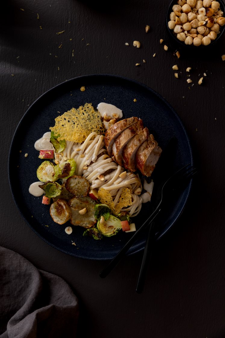 Svinefilet med steinsoppkremet pasta, servert med jordskokk- og rosenkålsalat og ostechips