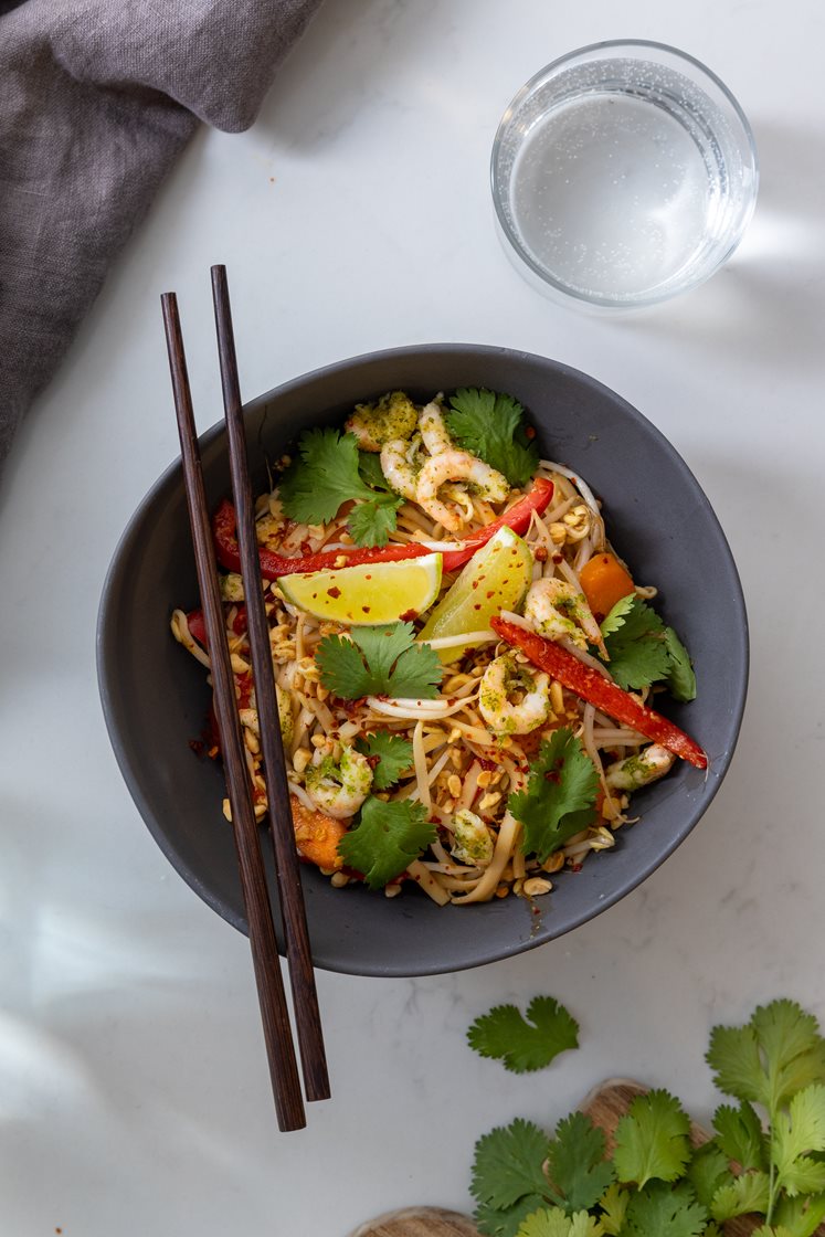 Pad thai med håndpillede reker og eggenudler, servert med bønnespirer, peanøtter og koriander