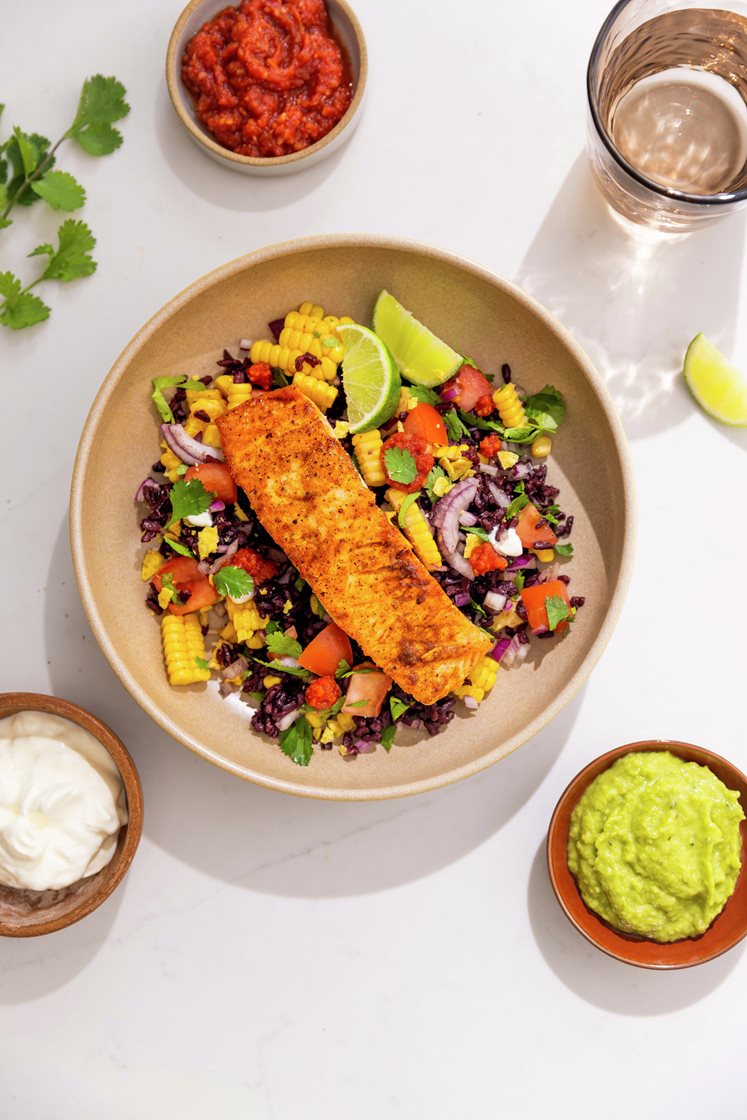 Tacokrydret laksefilet og salat med tomat, mais og svart ris, servert med guacamole og tortillakrønsj