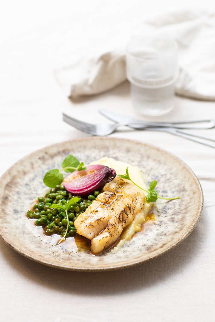 Torskefilet med mørbakt rødløk, pastinakkpuré, kokte poteter og mynteglaserte erter