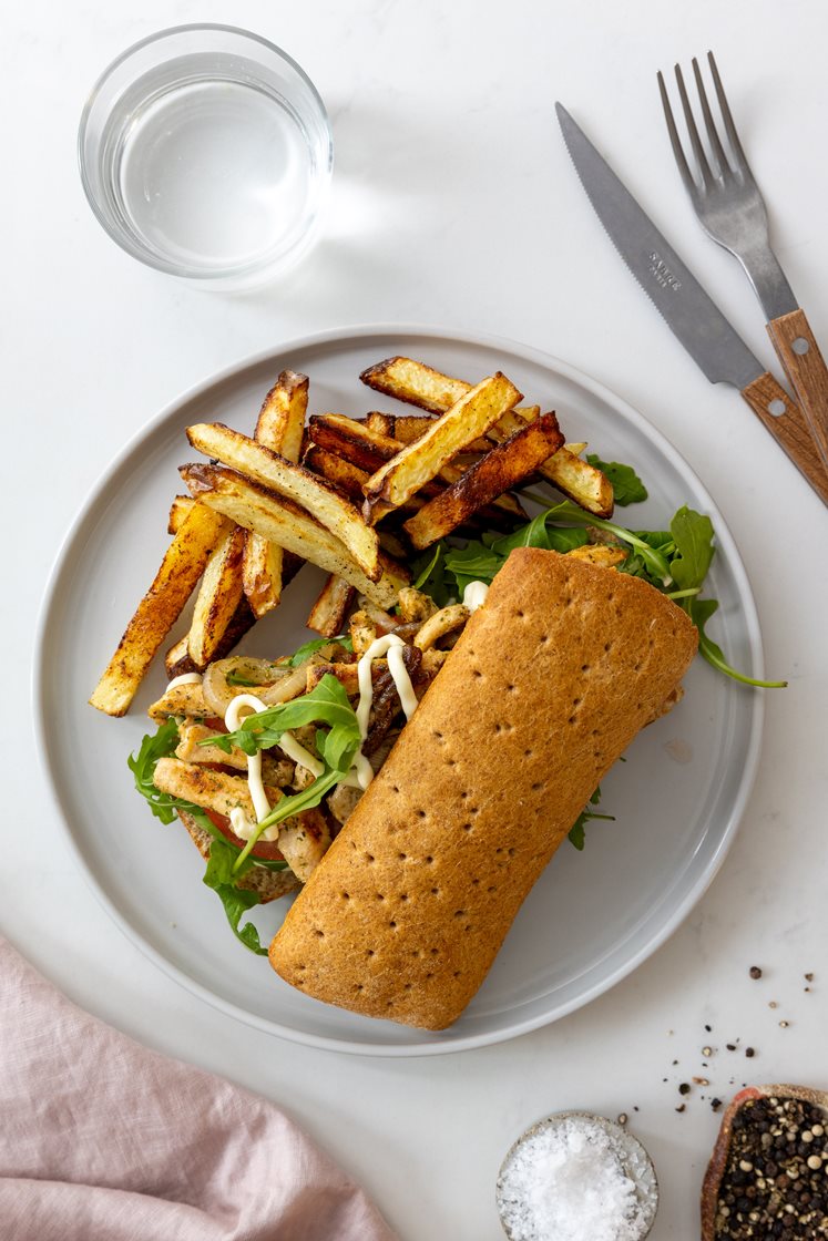 Kyllingsandwich med stekt løk, tomat og ruccola, servert med trøffelaioli og potetfries