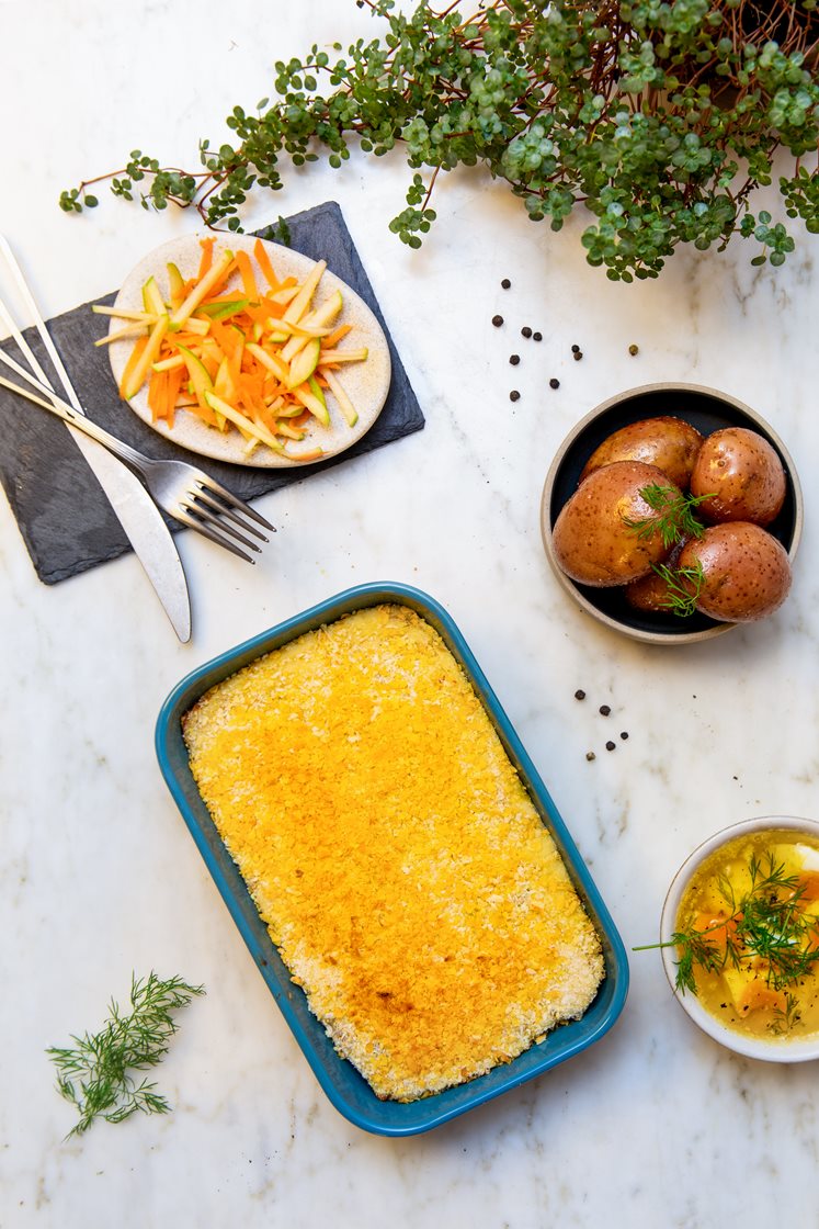 Fiskegrateng med kokte poteter og råkostsalat med eple, servert med eggesmør