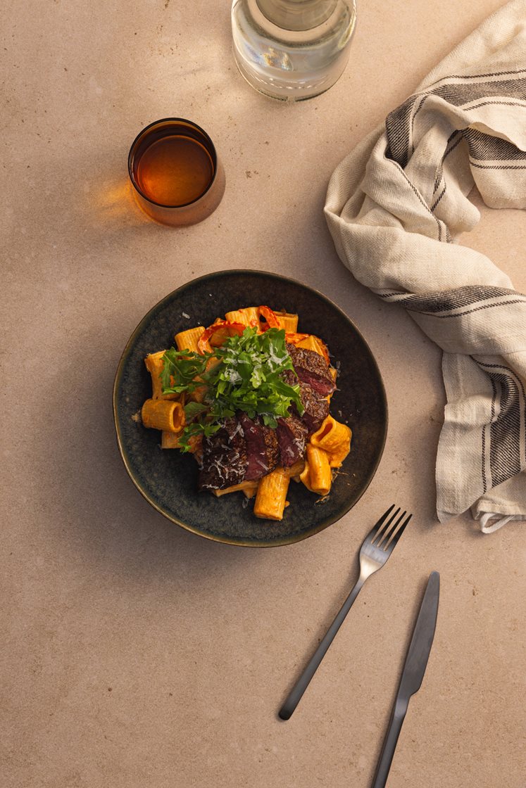 Paprikakremet pasta med tynnskåret mørbrad servert med ruccola og Grana Padano