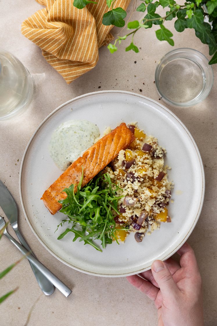 Pannestekt laksefilet og bulgur med paprika og løk, servert med krydret yoghurtdressing og ruccola