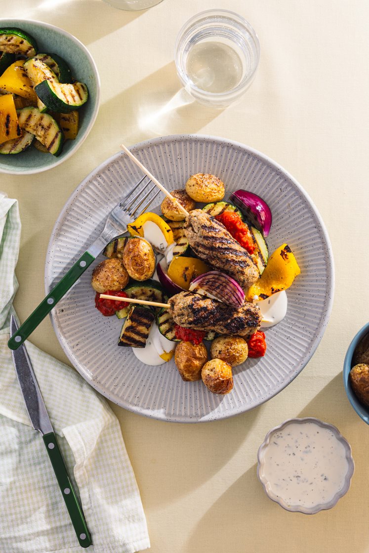 Grillet salsicciaspyd med urtepoteter, paprika og squash, servert med ajvar og urtedressing