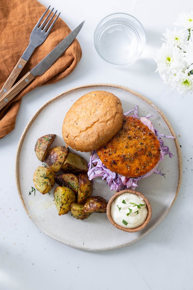 Ørretburger med cheddar og urter, servert med stekte dillpoteter, eple og rødkålslaw 