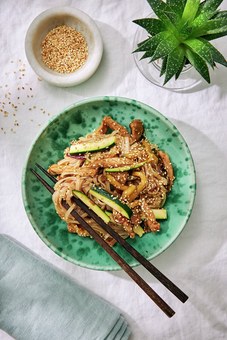 Asiatisk fläskwok med zucchini, champinjoner, risnudlar och sesamfrön