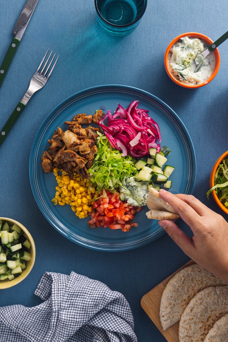 Grillet gyroskjøtt i varme pitabrød, servert med syltet rødløk og tzatziki