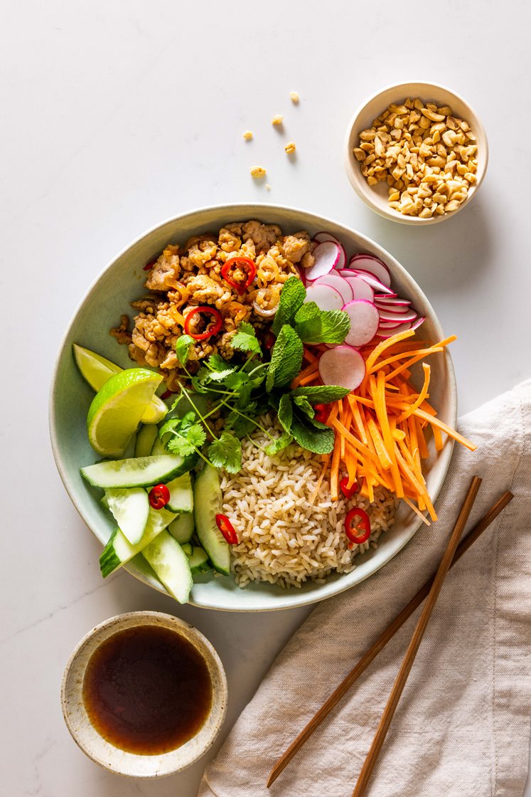 Vietnamesisk ricebowl med kyllingkjøttdeig og friske grønnsaker, servert med mynte og hakkede peanøtter