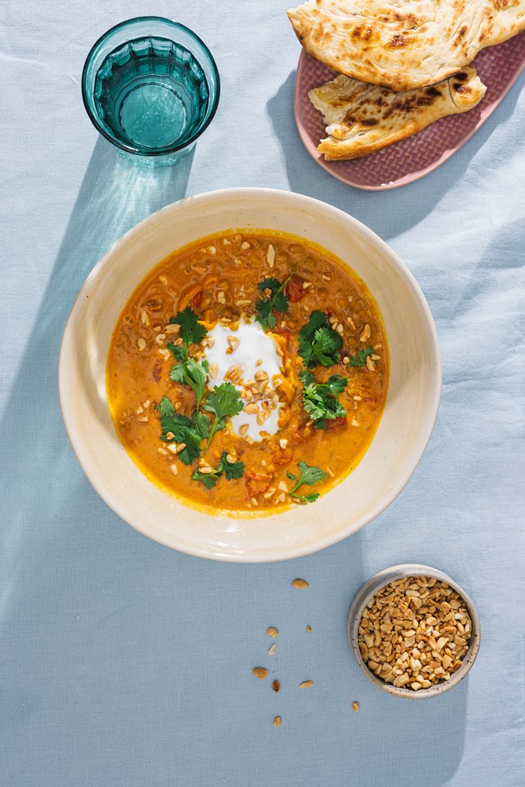 Indisk linsesuppe med koriander og yoghurt, servert med nanbrød og nøtter