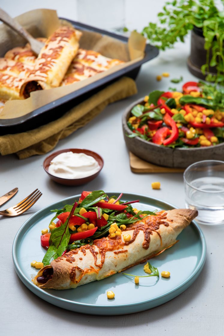 Gratinerte burritoer fylt med ferdiglaget chili con carne, med salat og rømme