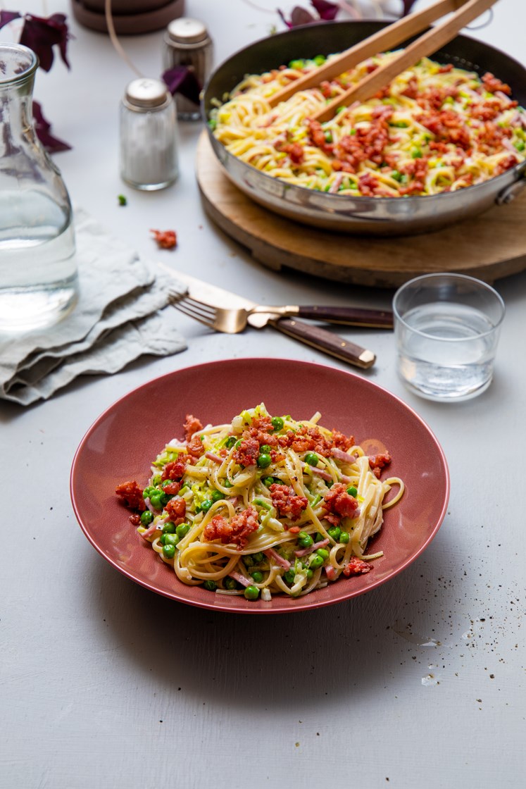 Kremet pasta linguini med bacon, skinke og grønne erter