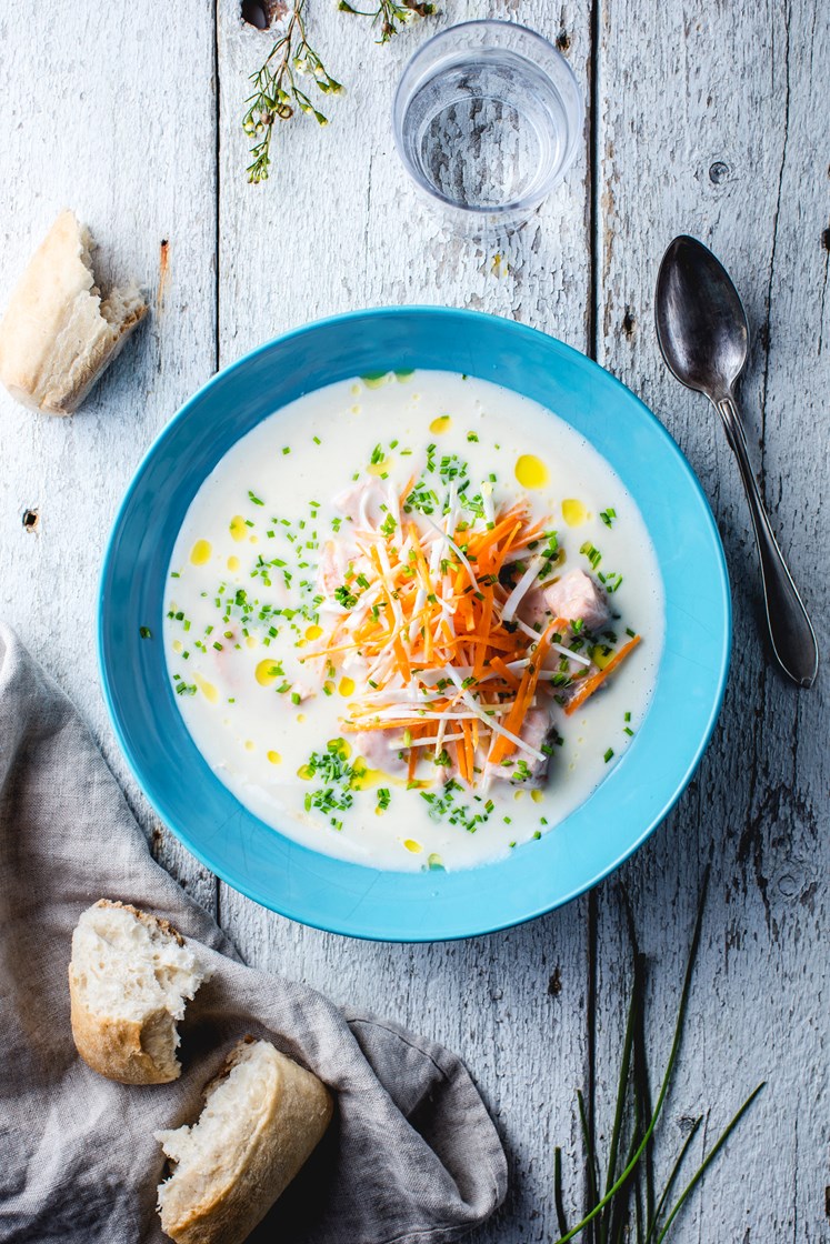 Fiskesuppe med laks, rotgrønnsaker og gressløk servert med steinovnsbakte rundstykker