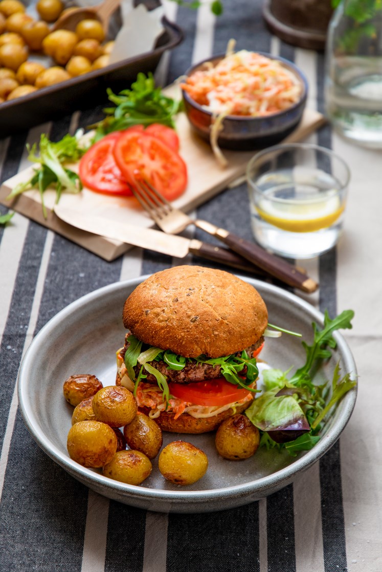 Klassisk hamburger med frisk salat, coleslaw og ovnsbakte småpoteter
