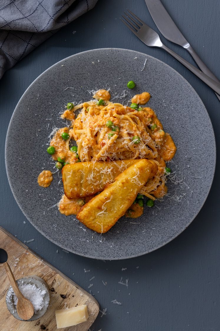 Panert sei og paprikakremet pasta med grønne erter og revet ost 