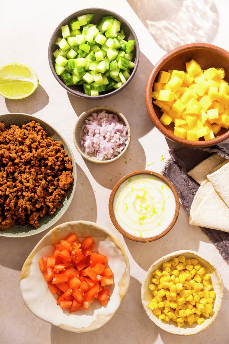 Taco med kjøtt- og linsedeig, mango, friske grønnsaker og fullkornstortillaer, servert med søt limeyoghurt