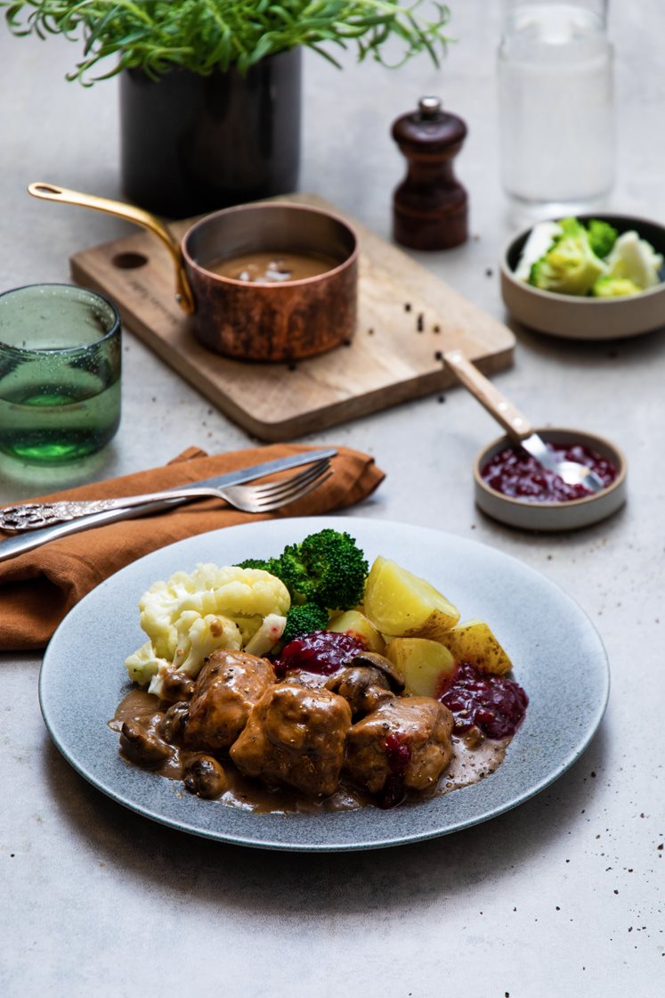 Medisterkaker i soppsaus med brokkoli- og blomkålbuketter og rørte tyttebær