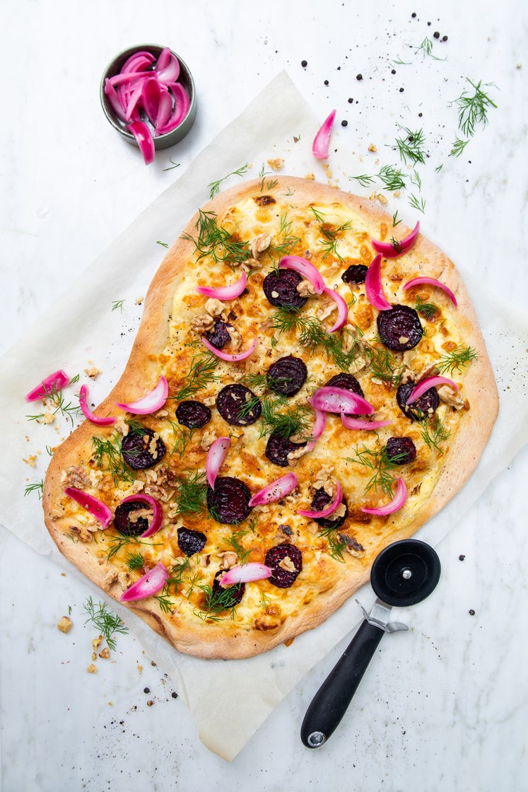 Hvit pizza med rødbeteskiver, valnøtter, syltet rødløk og dill